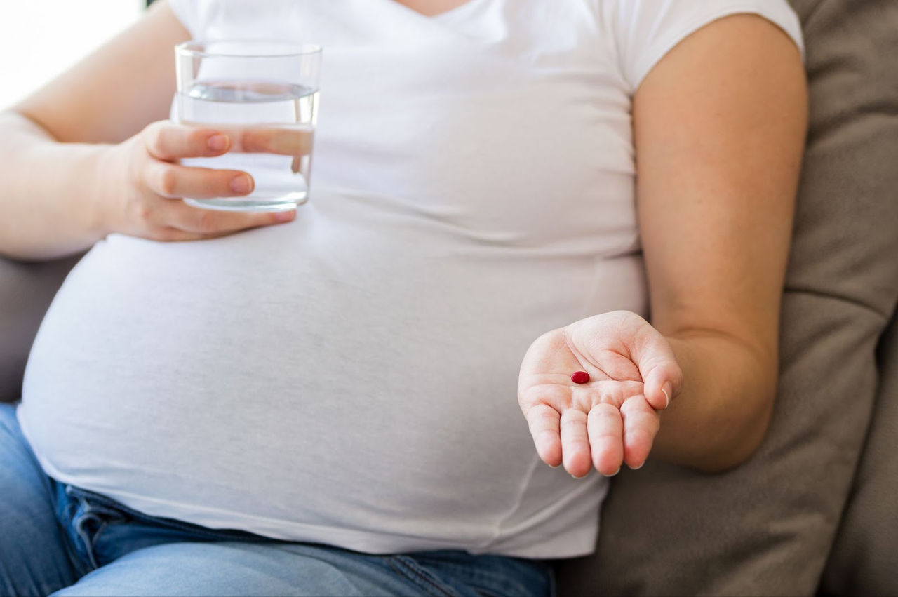 close up of asian pregnant woman lying in hospital ward has uterus utltrasonographic diagnosis - female doctor scans her uterus and shows on screen